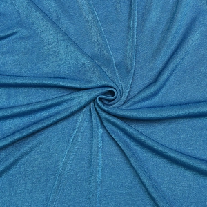 Macro shot of blue dress fabric showing smooth texture and elegant draped folds