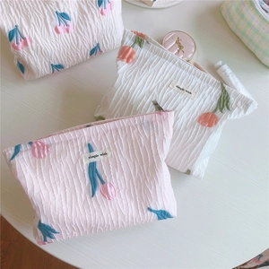 Gros plan de la broderie tulipe sur une trousse de maquillage en tissu gaufré