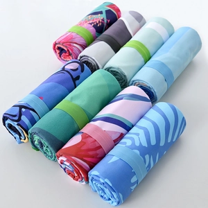 Detail view of rolled quick-dry beach towels with various patterns and elastic straps