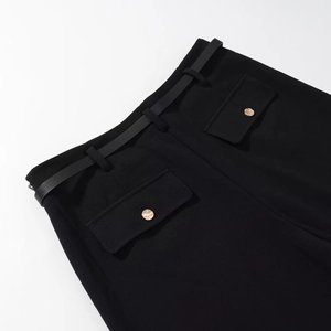 Dettaglio di pantaloni neri casual con cintura in vita e bottoni dorati martellati decorativi