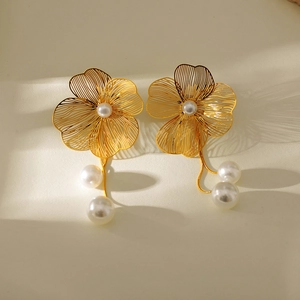 Detail of gold hollow flower earrings featuring elegant hanging pearl pendants