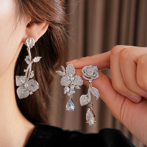 Nahaufnahme der silbernen Blumen-Ohrringe mit glitzerndem Zirkon-Wassertropfen-Anhänger