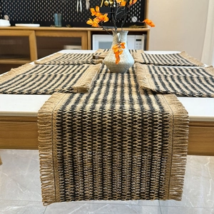 Five-piece set of woven paper placemats and table runner with black stripes and fringe