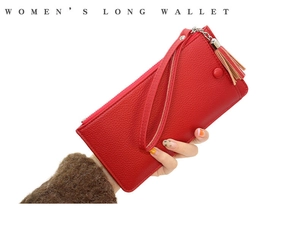 Detail of red litchi texture leather women's long wallet with tassel and wristlet strap
