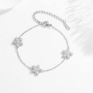 Detail of silver stainless steel chain bracelet with three elegant five-petal flower charms