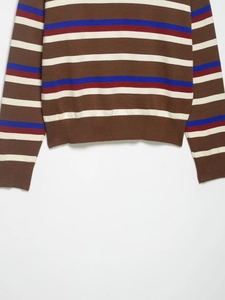 Detailed close-up of colorful striped knit sweater showing ribbed cuff and hem texture