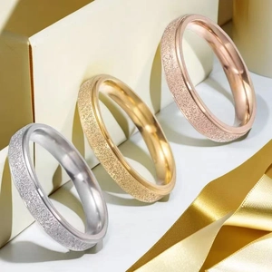 Close-up of three-piece stainless steel rings in silver, gold, and rose gold sandblast finish