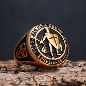 Macro detail of gold shield ring with red cross and Ephesians 6:13-17 scripture engraving