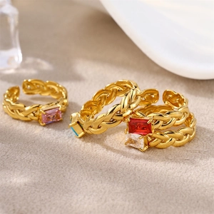 Detail of woven gold rings with rectangular colored cubic zirconia and adjustable band