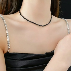 Close-up of elegant black crystal beaded necklace worn by model on neck