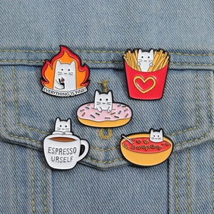 Five-piece set of cartoon cat enamel pins on blue denim pocket featuring cute food themes