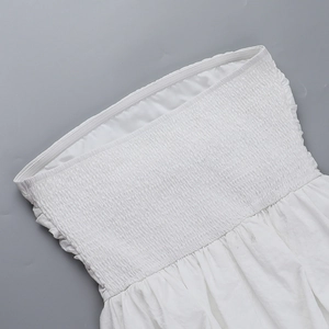 Gros plan sur la robe moulante blanche montrant la texture détaillée du tissu plissé