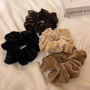 Lot de quatre chouchous larges en velours aux tons automnaux sur fond en tissu beige
