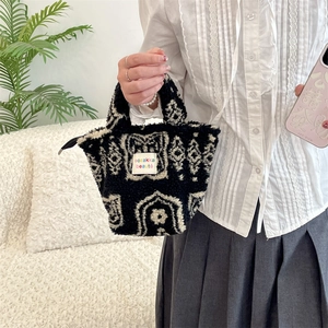 Detailed view of plush lambskin tote bag with black and white retro pattern and zipper