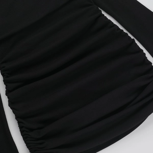 Dettaglio ravvicinato del tessuto a coste nero con design arricciato e dettagli a coulisse