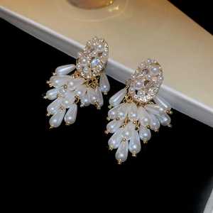 Detailed close-up of pearl and rhinestone tassel earrings with a golden finish