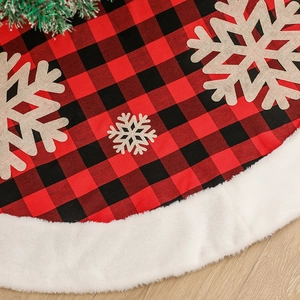 Red and black plaid Christmas tree skirt with beige snowflakes and white faux fur trim