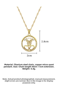 Macro detail of gold butterfly and heart pendant with zirconia on titanium steel chain