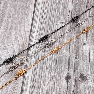 Detailed close-up of stylish spring-connector necklaces in black, silver and gold metal