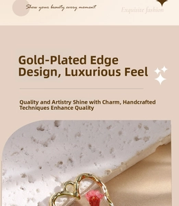 Macro shot of heart-shaped resin earring with red dried daisy flowers and gold-plated edges