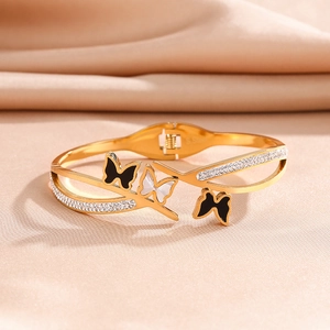 Detail showing gold butterfly bangle with black enamel, white shell and zircon accents