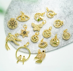 Detail of 18K gold plated charms with zircon stones including bird and evil eye symbols