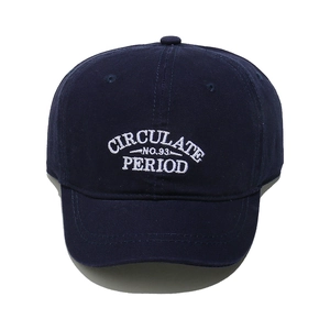 Close-up of white embroidered letters on a navy blue cotton twill baseball cap
