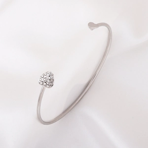 Silver open heart bracelet with sparkling crystals on white silk background