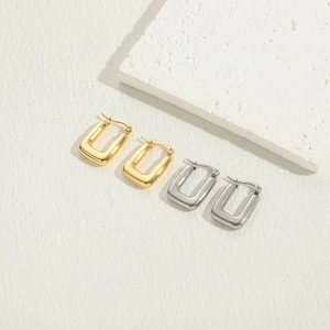 Detail of rectangular minimalist hoop earrings in polished gold and silver finishes