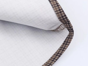 Macro detail showing high-quality plaid binding and precise white lining stitching