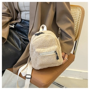 Nahaufnahme des cremeweißen Mini-Rucksacks aus Teddyplüsch mit Reißverschluss-Detail