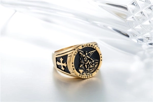 Detail of St. Michael engraving and cross relief on a gold and black titanium steel ring