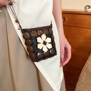 Detail view of ethnic crossbody bag with coconut shell discs and resin flower accent