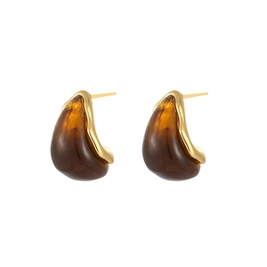 Macro detail of French teardrop earrings with 18K gold plating and amber resin inlay