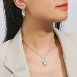 Elegant silver-tone zirconia necklace and earrings set shown on a female model