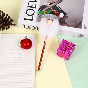 Détail d'un stylo à bille de Noël avec figurine Père Noël 3D et décors festifs