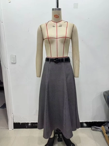 Detail of high waist plaid midi skirt with a black leather belt and flared hemline