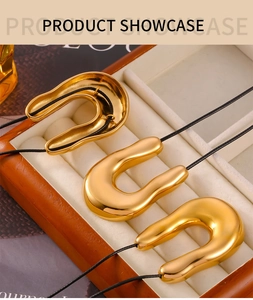 Three gold U-shaped necklaces on black cords displayed in a premium wooden jewelry box