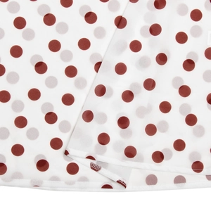 Close-up of white chiffon fabric with red and grey polka dots and hem stitching details