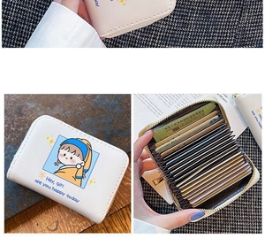 Detail of a beige accordion card wallet with cartoon art and multi-slot interior