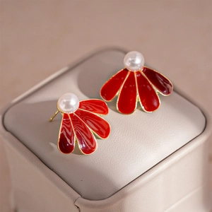 Detail view of vintage red enamel fan earrings with gold plating and white pearl accents