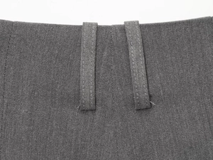Detail van de tailleband en riemlussen op grijze geweven stoffen shorts