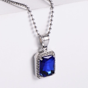 Close-up of hip hop pendant with rectangular blue gemstone and silver bead chain