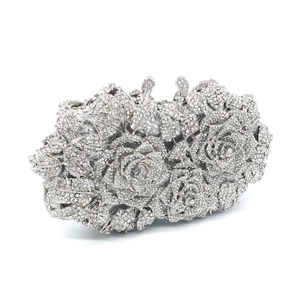 Detailed close-up of silver luxury evening clutch with 3D rose shape and rhinestones
