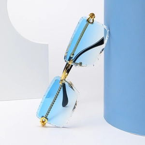 Detalle de gafas de sol sin montura degradado azul claro y patillas de oro metal
