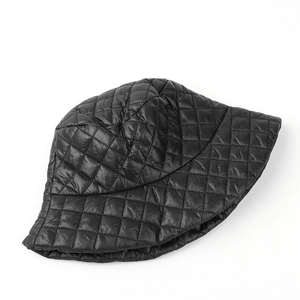 Detail view of black quilted bucket hat featuring classic diamond lattice texture