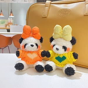 Gros plan de mignons pandas en peluche avec pulls tricotés et grands nœuds colorés