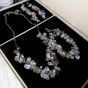 Detailed view of silver flower and rhinestone jewelry set in a luxury black velvet box
