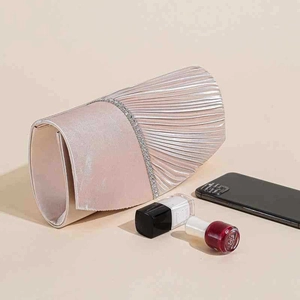 Dettaglio della borsa da sera in raso rosa champagne con pieghe e bordo in strass diagonale