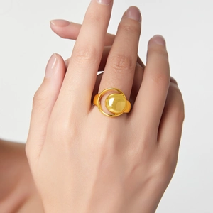 Minimalist hollow moon geometric gold plated ring worn on model finger over grey background